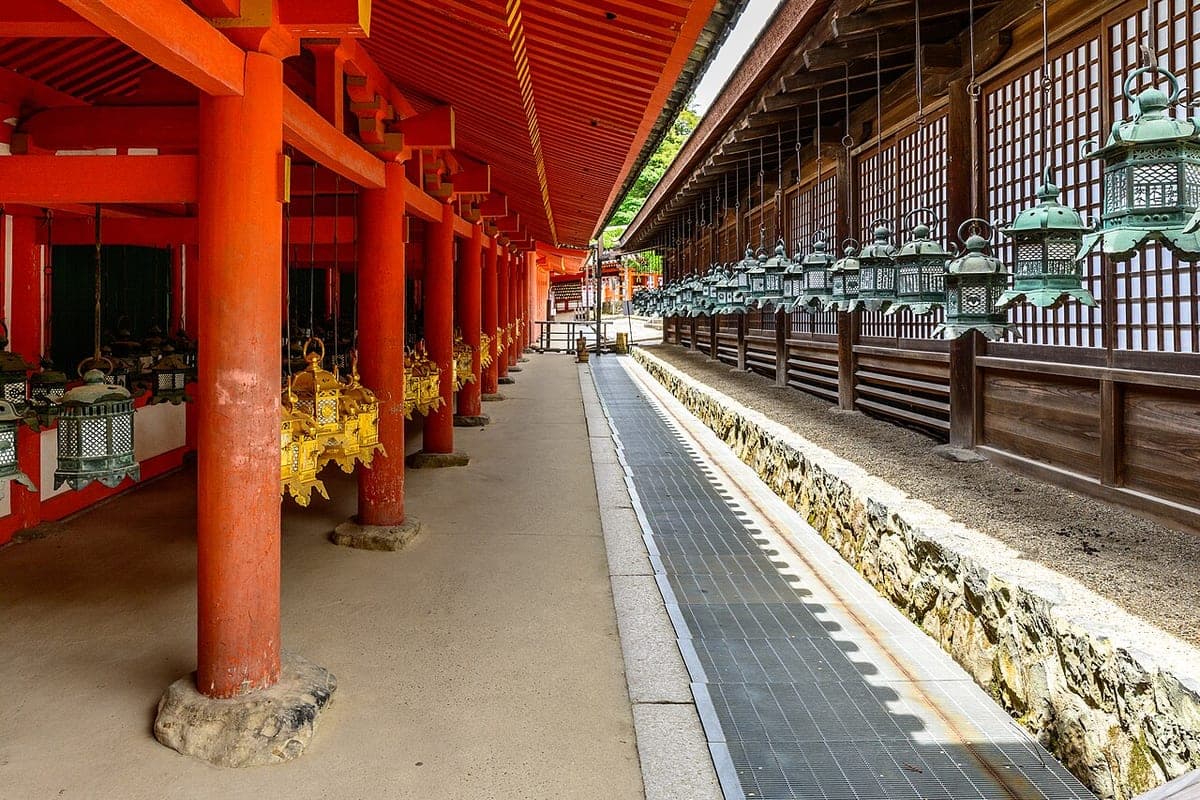 Un corredor bermellón de Kasuga Taisha con filas de faroles de bronce colgados